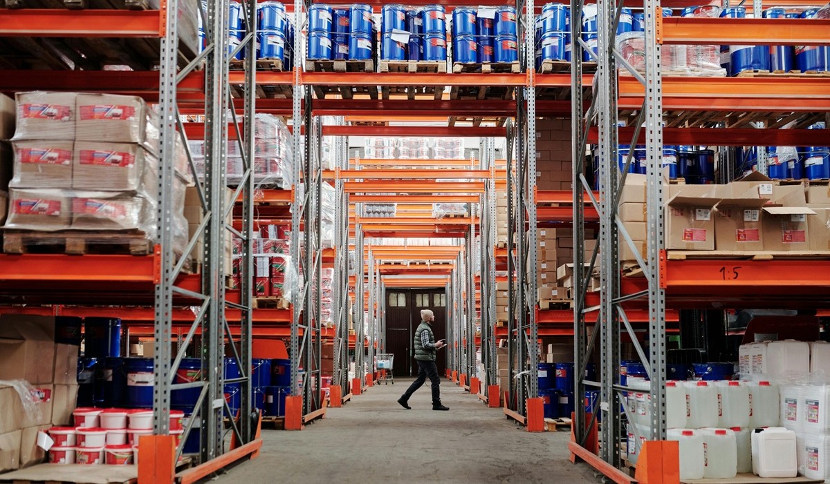 Warehouse aisles with stacked inventory pallets and racking